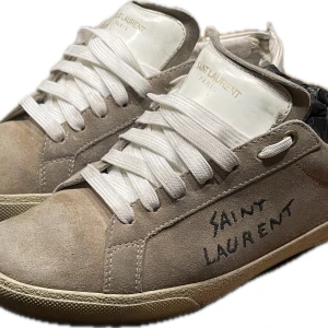 Saint Laurent beige sneakers mocka - Ett par väldigt snygga Saint Laurent skor! Storlek 40. Skicket är sådär så därav priset. Kontakta gärna vid intresse😊