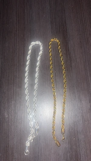 Två tvinnade kedjehalsband silver & guld - Säljer två snygga halsband med tvinnad kedja, ett i glansig 10mm silverfärg och ett 8mm i guldig ton. Båda har karbinlås och en chunky känsla som sticker ut. Perfekt för att mixa och matcha till olika outfits.