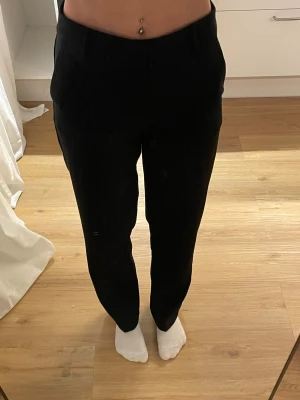 Svarta kostymbyxor Gina Tricot - Kostymbyxor från Gina Tricot i storlek 32. De har en rak och klassisk passform med hög midja och diskreta fickor fram. 