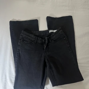 Svarta lågmidjade bootcut jeans - Snygga svarta lågmidjade bootcut jeans från Vero Moda Jeansen har en bootcut passform och är tillverkade i mjukt denim-material som sitter skönt hela dagen. Perfekta att matcha med sneakers eller boots för en cool look.