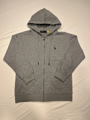 Grå hoodie  - Snygg grå hoodie med dragkedja och huva. Tröjan har långa ärmar, ribbade muddar och snörning i huvan.  Perfekt för chill dagar och enkel att matcha med jeans eller joggers. Hör av er vid frågor😊Pris kan diskuteras!