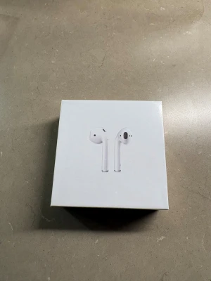 AirPods gen 2 med trådlöst laddningsetui - Säljer ett par AirPods gen2 med trådlöst laddningsetui. Komplett med originalkartong, laddkabel och manual. Hörlurarna är i mycket fint skick och fungerar utmärkt. Perfekt för trådlös musik och samtal. Inga synliga defekter eller slitage.
