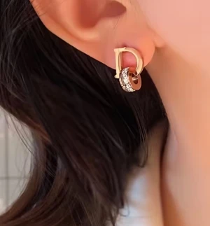 Guldiga örhängen med D-form och kristaller - Snygga örhängen i guldton med en stilren D-formad design och en rund detalj med glittrande kristaller. Perfekt för dig som vill ha något unikt och trendigt som sticker ut. Passar till alla tillfällen när du vill addera lite extra bling till din look. perfect for gift and if you buy now you will get freebies