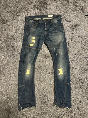 Blå jeans från Emilio Denim med slitningar - Säljer ett par coola blå jeans från Emilio i storlek 33/32