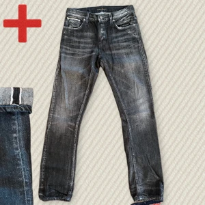 Svarta Nudie Jeans Grim Tim Selvedge - Ett par riktigt snygga svarta selvedge Nudie Grim Tim i storlek 31/32 från 2014! Sällsynta och har fina blåa detaljer. Riktigt fint skick, inga skador. Skriv om du har frågor!  Mått: Midja – 41 cm, Lår – 27,5 cm, Innersöm – 83 cm, Yttersöm – 110 cm, Benöppning – 18 cm