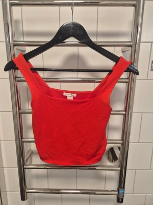 Röd topp  - Snygg röd linnetopp från Amisu med breda axelband och fyrkantig ringning. har en tight passform som framhäver siluetten. 