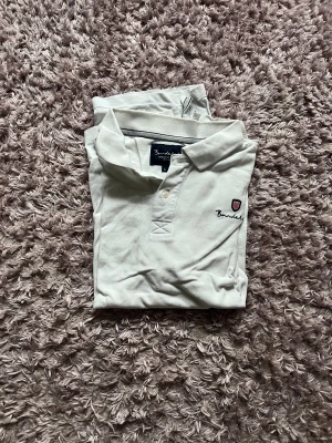 Vit bondelid piké  - Vit snygg bondelid piké som användes väl men i fortfarande topp skick. Storlek L men passar lätt M eller S för en mer baggy passform. Bvsa 😊