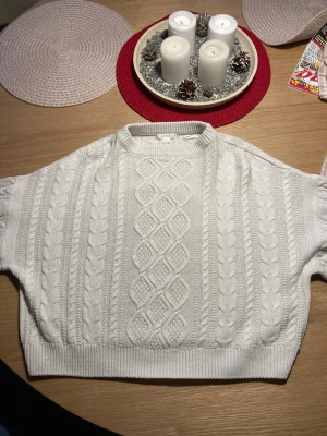 Vit stickad tröja från Gina Tricot - Superfin vit stickad tröja från Gina Tricot med klassiskt flätmönster och ribbade muddar. Tröjan har rund halsringning och långärmade ärmar, perfekt för lager på lager under kyliga dagar. Har använt de många gånger men har växt ut den. Den har inga hål o är helt felfri