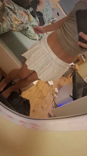 Vit kort kjol med broderade detaljer - Supersöt vit kort kjol med broderade hålmönster och volangkant. Kjolen har en bred linning och är lätt utställd för en flowy look. Perfekt för dig som gillar romantisk och feminin stil. Materialet känns som bomull och är mjukt mot huden.Om due intresserad så skriv t mej å vi fixar swich och kjolen i Gustavsberg 💕