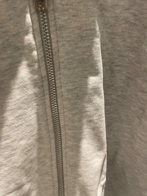 Grå fullziptröja från Weekday - Säljer nu en grå fullziptröja från Weekday. Tröjan är i bra skick och har endast en mindre fläck på framsidan (se sista bilden), men det går säkert bort med lite fläckborttagning. Tröjan är i storlek M men passar nog bättre för en S då den krympt lite i tvätten. Kan skickas 🤝🏼