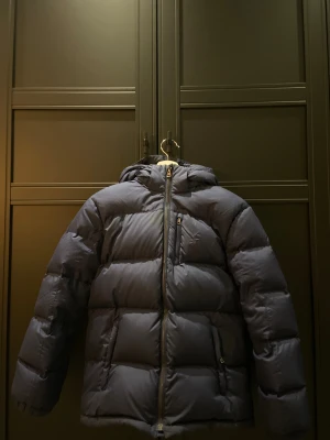 Mörkblå pufferjacka Polo Ralph Lauren - Säljer en mörkblå pufferjacka från Polo Ralph Lauren med luva och broderad logga. Jackan har dragkedja framtill. Perfekt för kalla dagar och har en schysst, oversized vibe. Nypris ca 3200kr, prisförslag mottages 