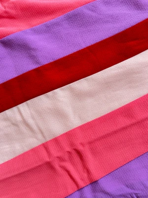 Färgglad långklänning från Nümph - festklänning  - Säljer en maxiklänning från Nümph med vertikala breda ränder i rosa, lila, röd och ljusrosa. Klänningen har rund hals, korta puffärmar och är tillverkad i ett mjukt, vävt material som känns skönt mot huden. Perfekt för dig som gillar färg och vill sticka ut. Nypris: 1400kr