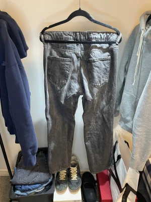 Grå loose fit jeans från H&M - Säljer ett par gråa jeans från H&M med loose fit och justerbar midja. Klassisk femficksmodell med raka ben och knappstängning fram. Jeansen har en snygg tvättad look och passar dig som gillar avslappnad stil.