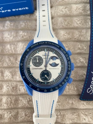 Omega x Swatch Speedmaster MoonSwatch - Säljer en Omega x Swatch Speedmaster MoonSwatch Super Blue Moonphase med blå boett och vit urtavla. Klockan har kronograf, månfaskomplikation och blå detaljer. Medföljer originalförpackning och extra blått textilband med Omega och Swatch-logga.