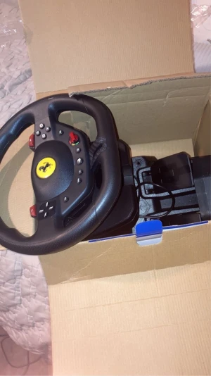 Thrustmaster T98 Ferrari 296 GTB Racing Wheel - Thrustmaster T98 Ferrari 296 GTB ratt och pedaler för PlayStation. Autentisk Ferrari-design, flera knappar och reglage för realistisk racingupplevelse. Produkten ser ut att vara i mycket gott skick och levereras i originalkartong.Och har kvitto!
