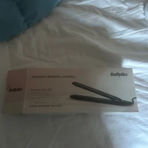 BaByliss Smooth Finish 230 - BaByliss Smooth Finish 230 plattång med titan-keramiska plattor och 3 värmeinställningar upp till 230°C. Ger ett slätt och glansigt resultat. Produkten ser ut att vara i gott skick och levereras med originalförpackning.