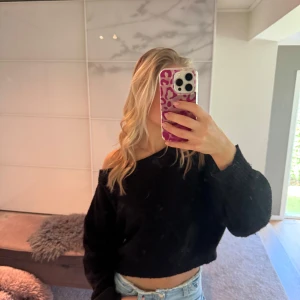 Svart croppad stickad tröja - Säljer en svart croppad stickad tröja med offshoulder-design. Tröjan är i gott skick och säljs pga användningsbrist💕