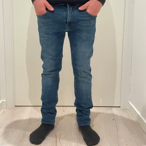 Blå Replay Anbass jeans slim fit - ( Modellen på bilden är 173cm lång)Säljer ett par blå Replay Anbass jeans med snygg tvätt och klassiska fem fickor. Jeansen har slim passform och raka ben, med diskreta slitningar för en modern look. Märkespatch bak i midjan och dragkedjegylf. Perfekta för dig som gillar stilrena jeans med bra passform. Det är bara att slå en pling 🛎️ ❗️kring några funderingar.