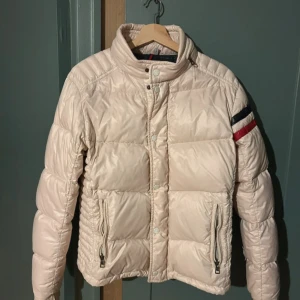 Beige pufferjacka från Moncler - Snygg beige pufferjacka från Moncler. Använd och har lite slitage inuti jackan vi ena ärmen men annars väldigt fin och bra skick!