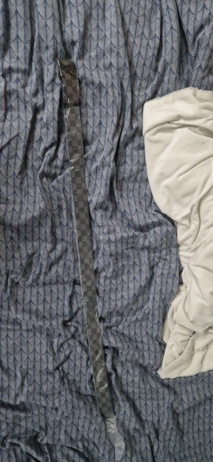 L V rutigt bälte i skinn - (Det är helt nytt och oanvänt)Säljer ett L V bälte i svart och grått med klassiskt rutigt mönster och L V-logga på spännet. Bältet är tillverkat i skinn med beige insida och har en stilren, fyrkantig form. Perfekt accessoar för dig som gillar exklusiva märken och vill ha en snygg detalj till outfiten.