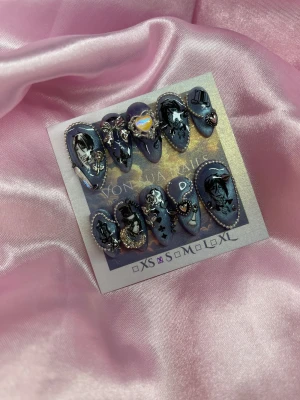 BlackButler(S);Medium Almond - Säljer ett set press-on naglar i blått med glittereffekt, dekorerade med silverdetaljer, 3D-hjärtan, rosetter och Black Butler anime-inspirerade motiv. Naglarna har en medium almond form och är prydda med små pärlor och metallaccessoarer för en unik look.S: 15 mm, 11,5 mm, 12 mm, 11 mm, 9 mm 