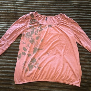 Rosa tröja med blommigt tryck  - Säljer en ljusrosa långärmad tröja från Soyaconcept med ett grått blommigt tryck på ena axeln och framsidan. Gissar att den är i storlek M