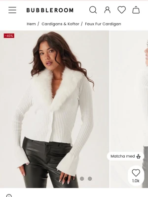 Vit ribbad kofta med fuskpäls från Bubbleroom - Supersnygg vit ribbad kofta med fluffig fuskpäls runt kragen. HELT OANVÄND med prislapp, köpte till julfirande men använde aldrig till slut, säljer nu för att det är försent att lämna tillbaka. 