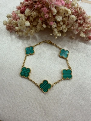 18k guldpläterat klöver armband  - Klöverarmband 15mm i rostfritt stål, pläterat med 18K guld 💎 I en vacker grön färg som ger en lyxig och sofistikerad känsla.  ✔️ Högkvalitativt rostfritt stål ✔️ 18K guldplätering ✔️ Justerbar längd: 19 cm till första hålet, 21 cm till andra ✔️ Slitstarkt & behåller sin lyster ✔️ Väldigt fint och stilrent utförande  🌸 Perfekt för dig som älskar tidlös elegans och hög kvalitet 📩 Beställ nu och fullända din look