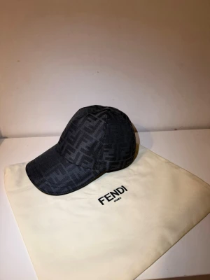 Fendi keps  - Bilderna visar en svart keps från Fendi med monogrammönster