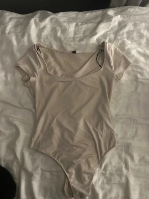 Basic body - Säljer denna fina beige bodyn. Bodyn har en fin passform och passar med allt!!
