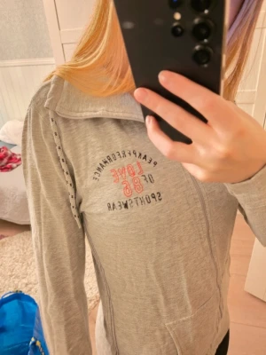 Grå hoodie - Jättefin grå hoodie från peak performance i storlek M i mycket bra skick! Dock lite sliten på loggan men syns knapt (se bild).