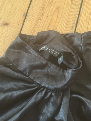 Cropad satin top  - Svart cropad satin top, perfekt att ha vid utgång. Saknar en av knapparna i nacken men sitter ändå bra på 