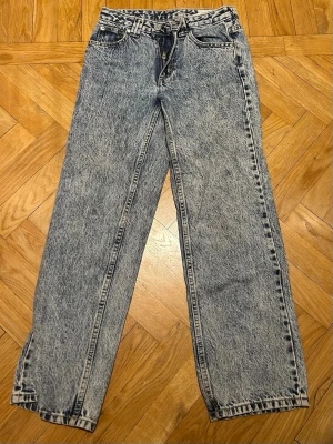 Acid wash jeans från WOW Denim - Säljer ett par snygga acid wash jeans från WOW Denim. De har rak passform, klassisk femficksdesign och hög midja. Jeansen är i blått med en cool tvättad look och är tillverkade i jeansmaterial. Perfekta för dig som gillar retrostil!