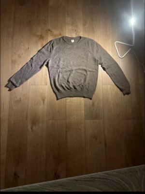 Brun stickad tröja från GAP - Mysig brun stickad tröja från GAP i storlek M. Klassisk rund halsringning och långa ärmar. Perfekt för lager på lager under höst och vinter. Enkel och stilren design som funkar till det mesta. Bröstvidd ca 50 cm.