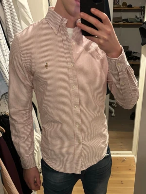 Rödvit randig skjorta från Ralph Lauren - Säljer en klassisk rödvit randig skjorta från Ralph Lauren, slingor. Inga tecken på användning, toppskick. Riktigt chill skjorta