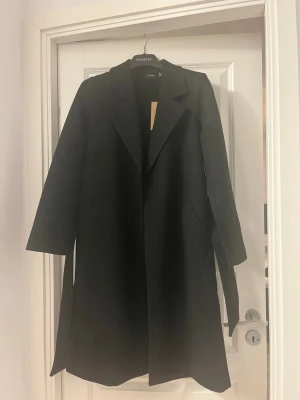 Svart långkappa - Svart långkappa med band, aldrig använd med prislapp kvar.