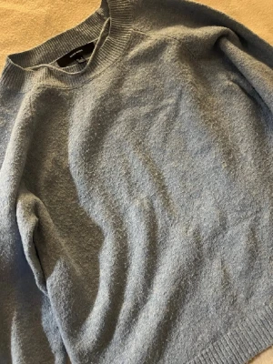 Ljusblå stickad tröja VERO MODA - Mysig ljusblå stickad tröja från Vero moda. Tröjan har rund halsringning och ribbade muddar vid ärmslut och nederkant. Perfekt för lager på lager under kyliga dagar.