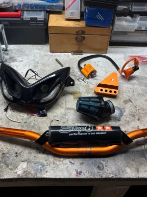 Aerox delar - Säljer ett orange styre från Stage6 med svart skydd och texten 'performance is our mission'. Passar perfekt till dig som vill ge din moped en sportig look. Flera delar i anodiserad aluminium och racingstil ingår.