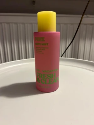 PINK Fresh & Clean Body Mist - Body mist med pineapple nectar, coconut milk och sea spray samt eteriska oljor. Flaskan rymmer 250 ml och har en färgglad design som sticker ut i väskan. Perfekt för dig som vill ha en fräsch och energigivande touch under dagen. HELT OANVÄND