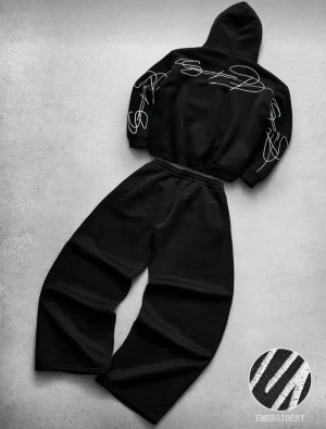 Svart broderad hoodie dress - Säljer en svart hoodie med huva och broderade vita linjer på ärmar och rygg. Hoodien har en avslappnad passform och är gjord i mjukt material som känns skönt mot huden. Perfekt för dig som gillar streetwear och vill sticka ut med coola detaljer.