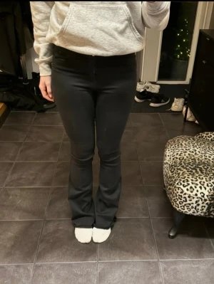 Svarta bootcut jeans - Säljer ett par svarta jeans med bootcut-modell. Byxorna har en smal passform upptill och släpper ut nedtill för en snygg siluett. De har fickor bak och är tillverkade i ett stretchigt material som sitter bekvämt. Passar storlekar 36 och 38!  