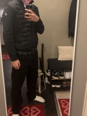 Svart Moncler pufferjacka med dragkedja - Säljer en svart cardigan från Moncler med quiltad front och ärmar i mjukt material. Jackan har hög krage, två sidofickor med dragkedja och klassisk Moncler-logga på ärmen. Perfekt för dig som vill ha en stilren och bekväm jacka. Nfc funkar. Kom pm för fler bilder eller frågor!😁 Pris ej hugget i sten så kom med pris förslag!