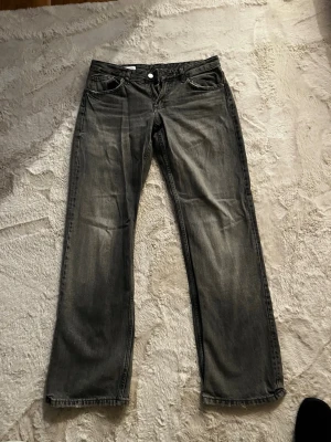 Grå raka jeans från Zara, strl 38 - Säljer ett par grå jeans från Zara i storlek 38. De har en rak passform och klassisk femficksdesign. Materialet är 88% bomull och 12% viskos.. Snygg tvättad look och passar perfekt till en avslappnad stil.