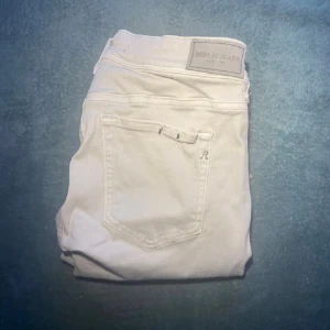 Vita jeans från Replay, W27 L30 - Snygga vita jeans från Replay med klassisk femficksdesign och diskret logga på bakfickan. Jeansen är i stretchig bomull och har normal midja. Perfekta för dig som gillar en clean och fräsch look.