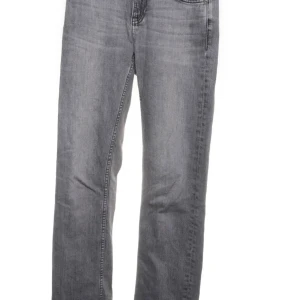 Grå jeans från Nudie Jeans - Snygga grå jeans från Nudie Jeans med klassisk femficksmodell och broderade bakfickor. Jeansen har rak passform och är tillverkade i mjukt denimtyg. Perfekta för dig som gillar en stilren och avslappnad look.