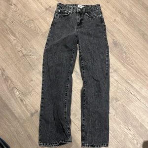 Svarta raka jeans från 157 Boulevard - Snygga svarta jeans från 157 Boulevard med klassisk femficksdesign och raka ben. Jeansen har hög midja och är tillverkade i ett slitstarkt bomullsmaterial med en cool tvättad look. Perfekta för dig som gillar en enkel och stilren vibe.