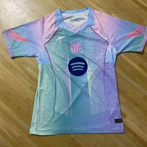 Barça x Nike pastell fotbollströja - Säljer en unik FC Barcelona fotbollströja från Nike i pastellfärger med klubbmärke och Spotify-logga på bröstet. Tröjan har korta ärmar, V-ringning och är tillverkad i lätt, ventilerande funktionsmaterial. Färgerna går i blått, lila, rosa och mintgrönt med grafiska detaljer.