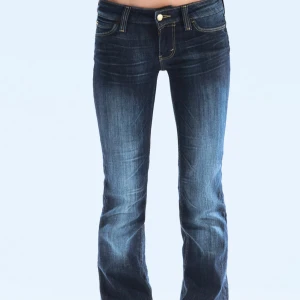 Mörkblå bootcut jeans Miss Sixty - Snygga mörkblå jeans från week day med bootcut passform och låg midja. Jeansen har klassiska fem fickor, guldfärgade detaljer och slitningar framtill för en cool look. Tillverkade i stretchig denim som sitter skönt och formar sig efter kroppen. Jeansen är helt oanvända då jag råka köpa fel storlek längd:32 midja:28