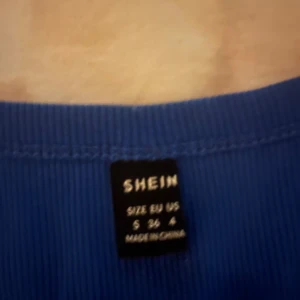 Blå croppad långärmad topp från SHEIN - Säljer en blå croppad långärmad topp från SHEIN i storlek S. Toppen har en rundad halsringning och är ribbad i materialet vilket ger en snygg och modern look. Perfekt att matcha med jeans eller kjol för en chill stil.