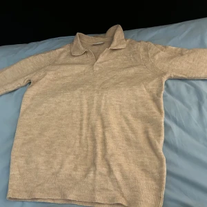 Beige pikétröja i ull från Only & Sons - Säljer en beige pikétröja från Only & Sons i mjuk ullblandning. Tröjan har klassisk krage, lång ärm och ribbade muddar vid ärmslut och nederkant. Perfekt för lager-på-lager och chill stil. 